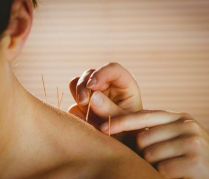 Therapist gently treating a patient's shoulder